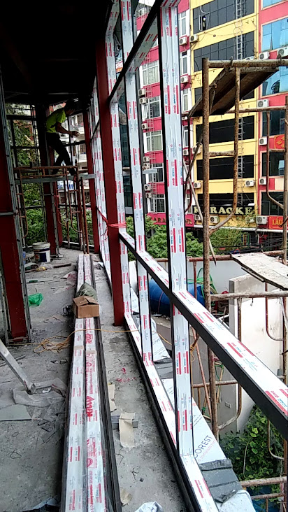 Thi công lắp đặt khung nhôm kính mặt tiền tòa nhà đang xây dựng